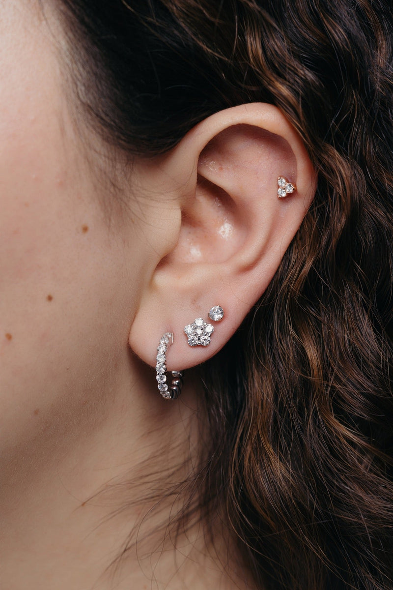 Oreja con arracada y broqueles apilados