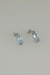 Aretes Aguamarina Corte Pera de Oro Blanco 14k, en segunda toma de estudio, desde otro ángulo.