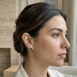 Broqueles Cieli de Oro Blanco 14k con esmeraldas, en uso, en la oreja de una mujer, en un retrato de perfil.