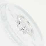 Anillo Cieli Corte Esmeralda de Oro Blanco 14k, en toma de estudio sobre una superficie de vidrio, con su reflejo a la vista.
