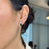 Broqueles Cieli de Oro Blanco 14k con esmeraldas, puestos en la oreja de una modelo.
