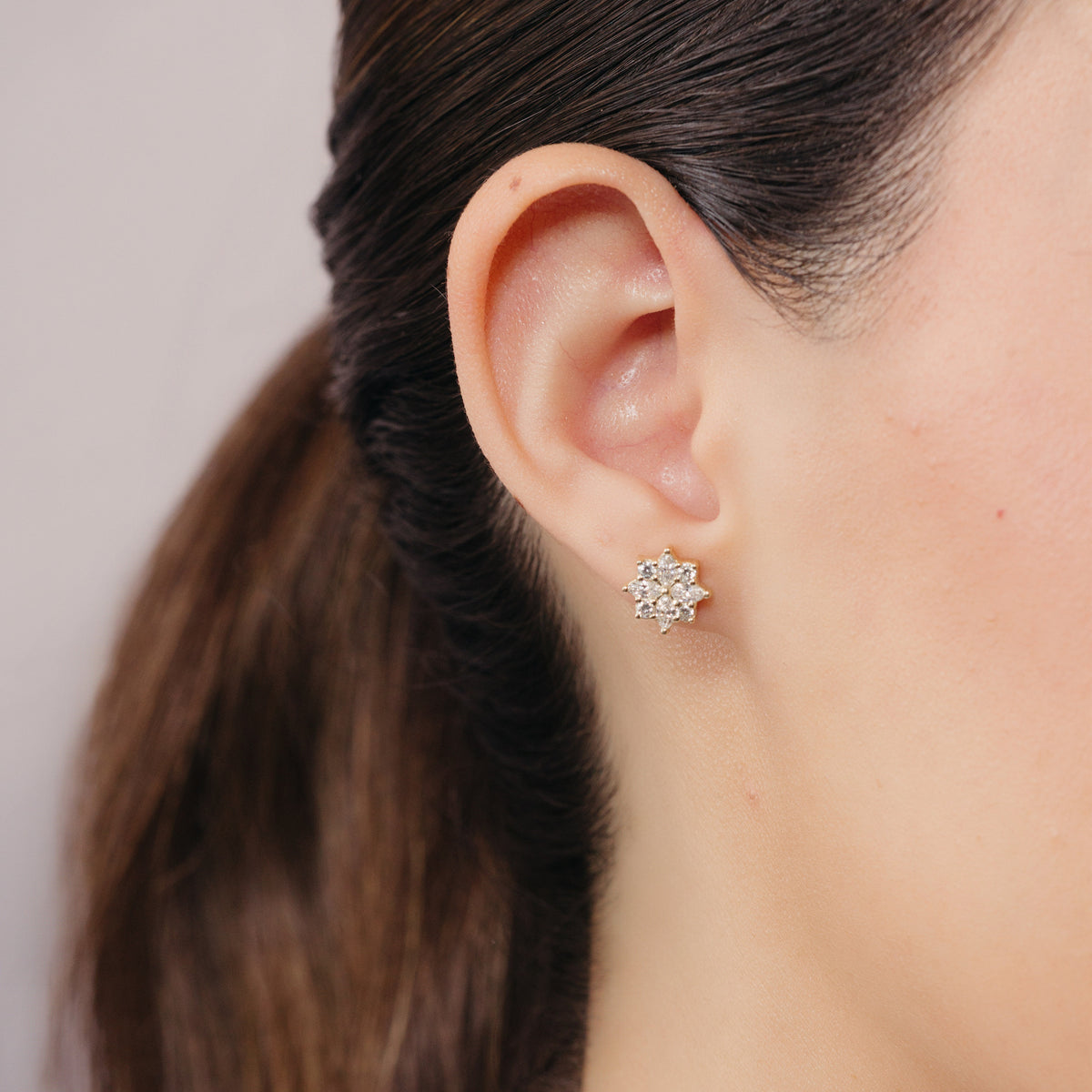 Broqueles Fiore de Oro Amarillo 14k puestos, vista de perfil de la oreja de una modelo.
